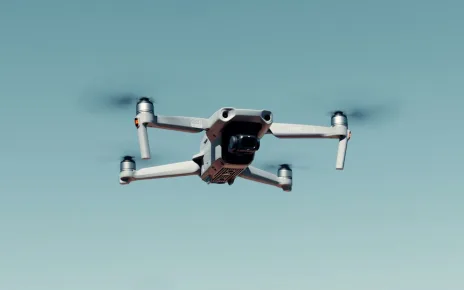 black and white drone flying under blue sky during daytime